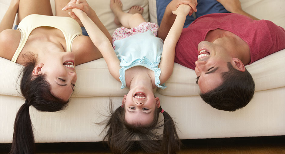 A Couple Laughing With Their Daughter